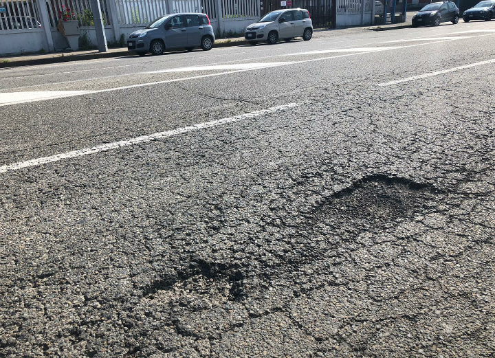 Via Reiss Romoli piena di buche profonde e pericolose: serve un intervento urgente