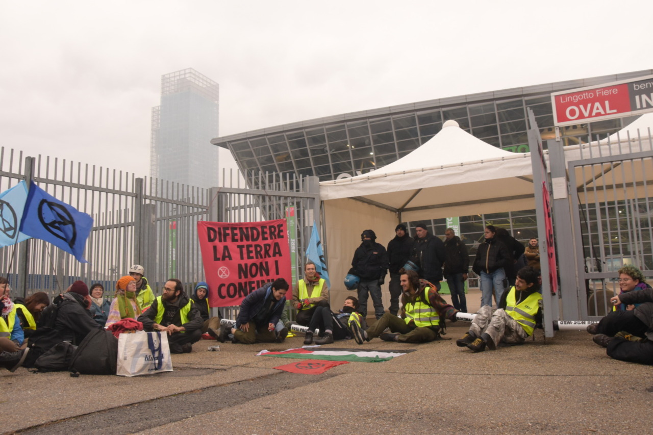 Extinction Rebellion blocca la convention della Difesa e dell’Aerospazio a Torino: “Difendere la Terra, non i confini”